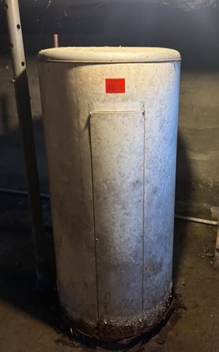 Old water heater prepared for appliance removal by JJs Cleanup